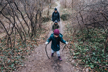 Family hiking forest trail during winter season
