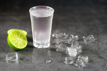 Vodka. Shots, glasses with vodka with ice and lime on gray background