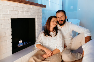 Adult couple enjoying cozy moment by modern bio fireplace