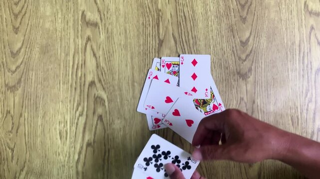 Hands playing cards for fun hobby and engaging leisure time activity.