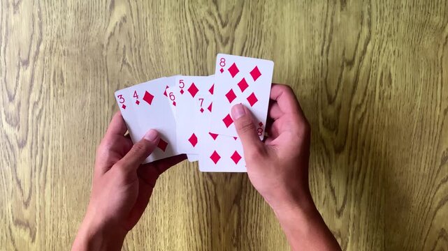 Hands playing cards for fun hobby and engaging leisure time activity.