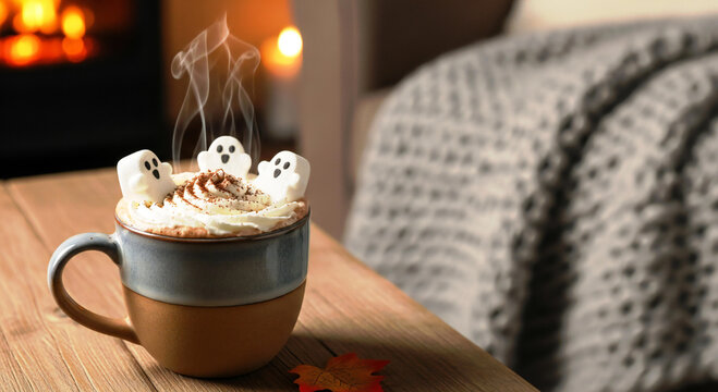 Cozy Halloween hot chocolate with marshmallow ghosts, a warm fireplace, and fall leaves create a perfect autumn scene for seasonal promotions and festive marketing campaigns