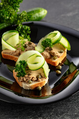 Open sandwiches with pate, fresh cucumber, capers, and parsley.