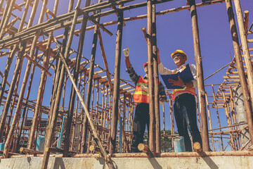 Structural engineer, architect and foreman worker with blueprints discuss, plan working for the outdoors building construction site. Construction collaboration concept