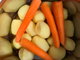 Close-up of peeled raw potatoes and carrots ready for cooking