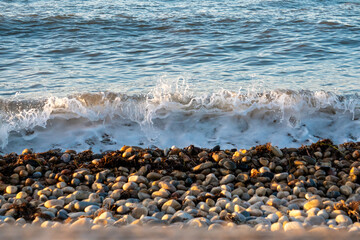 Waves crashing over pebbles