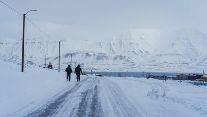Longyearbyen. Two persons walking around during winter season