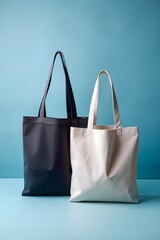 Two tote bags, one dark navy and one offwhite, placed on a blue surface against a matching blue background, highlighting their form and color