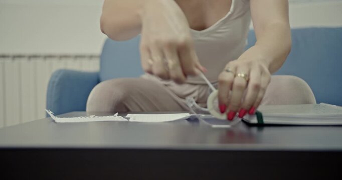 Detailed footage of a woman's hands meticulously using Scotch tape on paper, capturing the distinct and authentic sounds of this common home or office task.