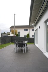 Modern patio furniture set on paving in backyard