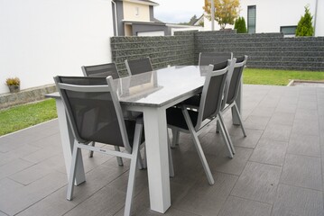 Modern patio furniture set on paving in backyard