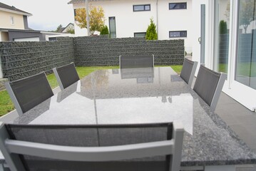Modern patio furniture set on paving in backyard