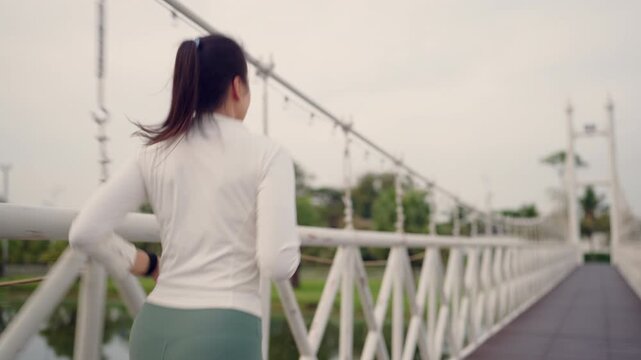 Focused woman running on white bridge symbolizing dedication and goal achievement in fitness. Active and healthy lifestyle in motion.