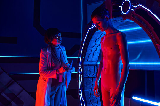 Scientist studies an alien being in a futuristic laboratory setting