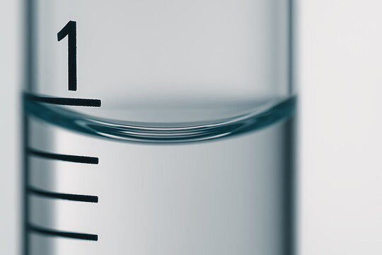 Macro photo of a transparent glass cylinder with a curved water meniscus aligning with the measuring mark, illustrating precision, clarity, and laboratory accuracy.