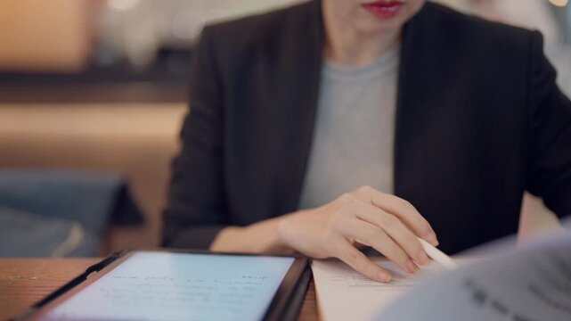 Modern education concept showing hand writing on digital tablet using stylus pen in a tech-friendly classroom.