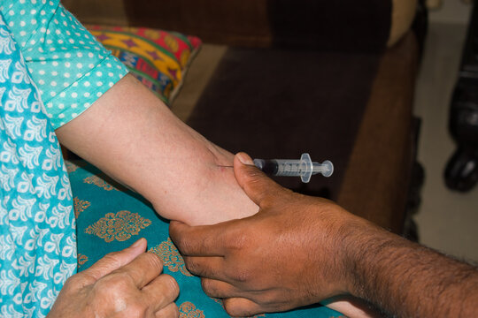Indian woman hand with blood sample syringe, senior healthcare and wellness in India