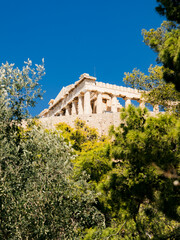 Fototapeta premium Odeon of Herodes Atticus theater on the Acropolis hill in Athens, Greece. Historic ancient amphitheater surrounded by Mediterranean trees under clear blue sky.