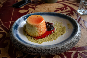 Goat cheese cheesecake drizzled with rich Port wine reduction, a gourmet dessert combining creamy cheese with sweet, fortified wine flavor.