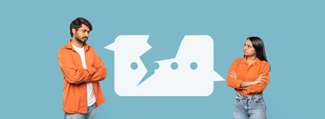 A man and a woman are standing with their arms crossed, facing each other with serious expressions. They are in a warm-colored environment.