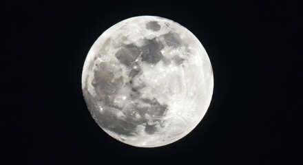 Fototapeta premium Detailed close-up of a full moon with visible craters against dark night sky