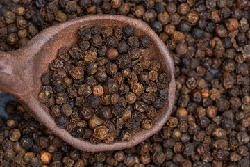 Black pepper grains that add flavor to dishes. Close-up of black pepper grains