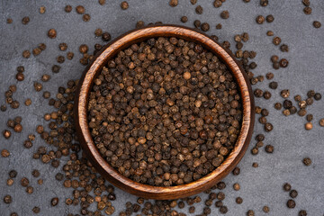 Black peppercorns on black stone table  background