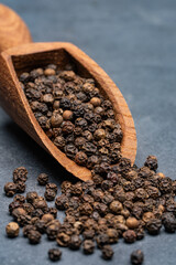 Black peppercorns on black stone table  background