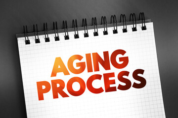 Aging process - gradual, continuous process of natural change that begins in early adulthood, text on notepad, concept background