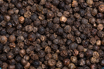 Black pepper grains that add flavor to dishes. Close-up of black pepper grains