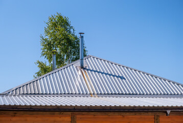 A thin iron chimney on the roof of the house.