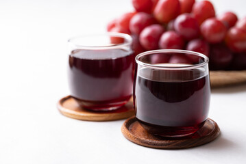 Red grape juice in glass and fresh grapes fruit on white background, Healthy drink
