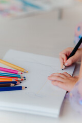 A Child Engaging in Drawing with Colored Pencils on a Completely Blank Page to Express Creativity