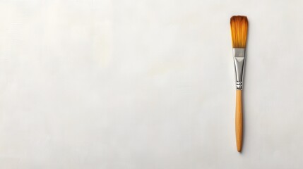 Creative paintbrush resting on a light textured surface ready for artistic projects and expression