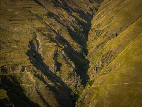 Aerial view of a gorge cuts through the landscape, casting stark shadows and revealing the rugged beauty of the terrain, Dartlo, Kakheti, Georgia.