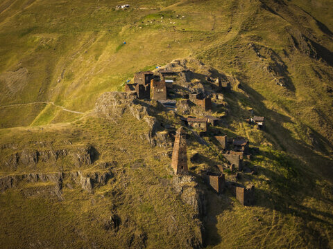 Aerial view of ancient stone towers and dwellings clinging to the rugged, sun-drenched slopes of Dartlo, a timeless fortress against the vast Caucasus, Dartlo, Kakheti, Georgia.