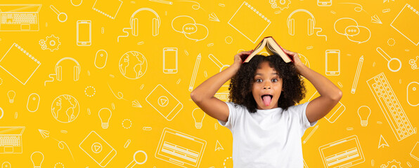 A child with curly hair shows a playful expression while holding a book on their head.
