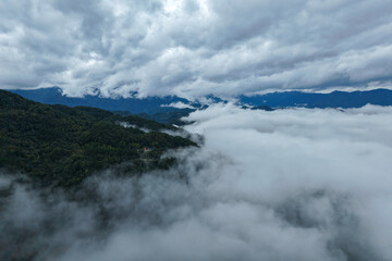 Enshi City Hubei Province mountains shrouded in low clouds over green forests.