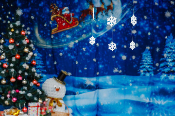 Festive Christmas scene with tree, snowman, and Santas sleigh backdrop
