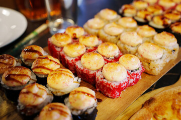 Sushi platter displayed with colorful rolls and creamy toppings at a restaurant