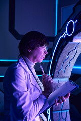 Scientist studies alien technology in a futuristic lab environment