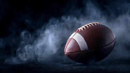 Football resting on a dark surface surrounded by smoke, capturing the essence of competitive sports in a dramatic setting