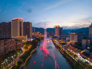 Xuan'en County Hubei Province China night city lights illuminate river fountains water flows.