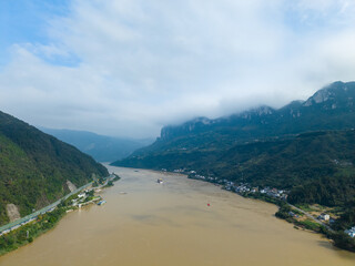 Yichang Three Gorges China river flows through vast mountains under cloudy skies