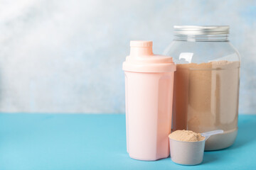 Protein shake with protein powder on a colored background. The powder is mixed with water or milk. A dietary supplement for a balanced diet. Whey protein. Fitness and gym diet nutrition.