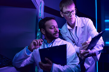 Scientists investigate alien technology in a high tech lab environment during twilight hours