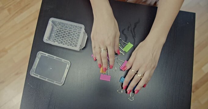 Observe the intricate hand movements as colorful binder clips are manipulated, producing satisfying and rhythmic sounds. Perfect for ASMR and relaxation content.