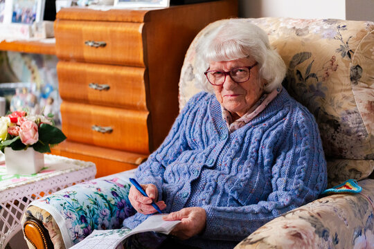 Senior person doing sudoku puzzle in loungeroom at home