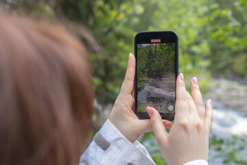 selective focus on hand using smart phone taking landscape photo or video