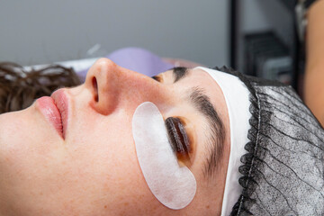 Close-up of cosmetologist doing lash lamination procedure